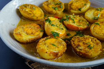 Traditional Bengali egg malaicurry or dim malaikari, boiled eggs cooked in rich coconut milk gravy with spices, authentic Indian curry from Bengal cuisine served with steamed rice as festive meal
