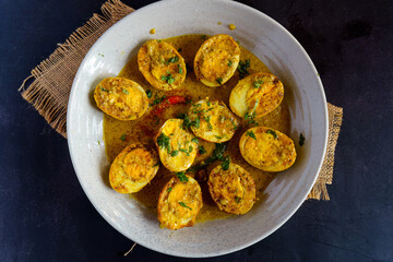 Traditional Bengali egg malaicurry or dim malaikari, boiled eggs cooked in rich coconut milk gravy with spices, authentic Indian curry from Bengal cuisine served with steamed rice as festive meal
