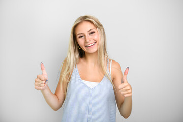 Pretty 18 years old blonde girl posing in studio look positive