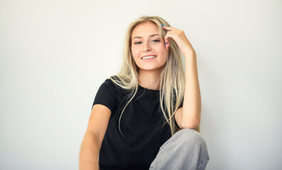 Pretty 18 years old blonde girl posing in studio with black shirt