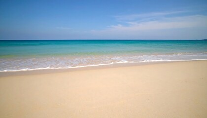 Obraz premium Wide, sandy beach meets a calm turquoise ocean under a clear blue sky