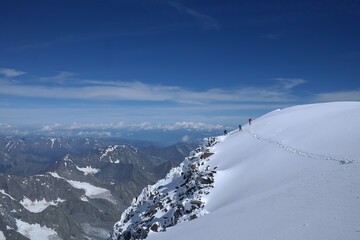 Adventurous hiker enjoying the breathtaking view from a snowy mountain peak