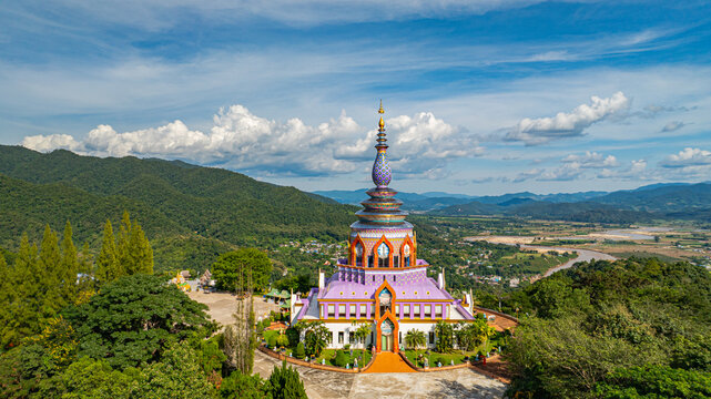 Aerial view of a colourful pagoda overlooking a green valley. pagoda at Wat Thaton on the banks of the Kok River in Chiang Mai Province near the border with Burma.fantastic pagoda of the tribal