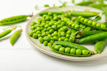 Fresh green pea pods with green peas on a wooden background. Sweet green peas. Green pea beans vegetables. Vegan. healthy vegetable. Copy space