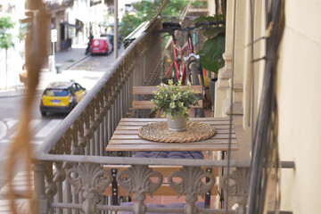 Balcony with table and chairs decorated with plants in urban street view