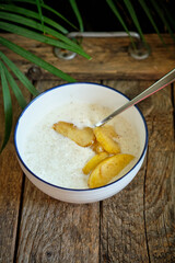 Rice pudding with apple. Side view, wooden background