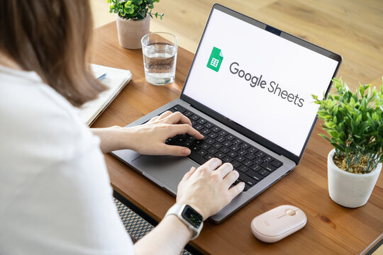 Poznan, Poland - August 23, 2025: Google Sheets application displayed on a laptop, a person typing, emphasizing data management, analysis, and collaborative digital workspace