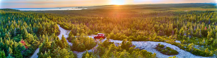 Aerial panorama of overland vehicle camped above the Bay of Fundy, New Brunswick Canada.