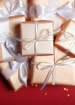 Gifts in gold packaging on a colored background with place for text.. Vertical photo format