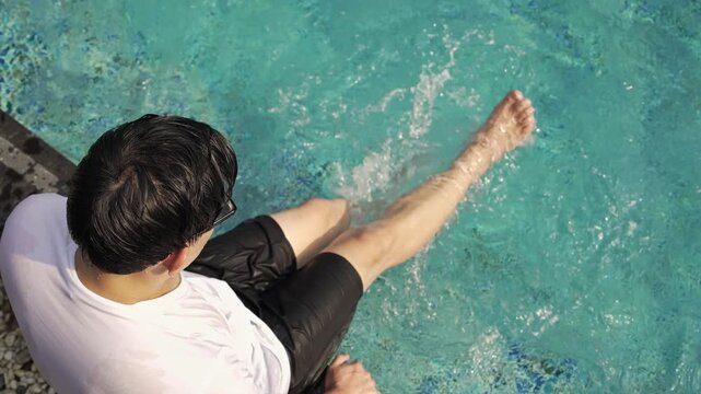 A man practice flutter kicking at the swimming pool, summer activity, relaxing on holiday weekend