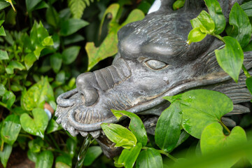 Bronze dragon fountain hidden in greenery on Enoshima Island, Japan