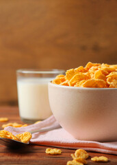 Delicious cornflakes in a plate on the table.. Vertical photo format