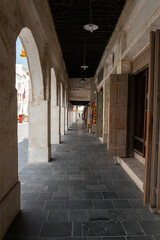 Traditional Qatari market with shops and storefronts, completely empty and without people. Historic Middle Eastern architecture and peaceful urban atmosphere.