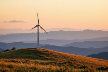 A single wind turbine stands on a grassy hill against a layered mountain range at sunset