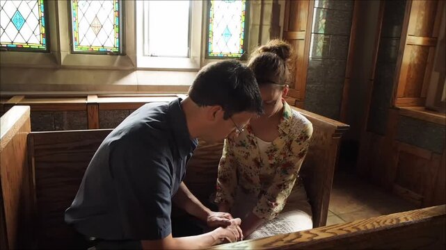 Couple Kneeling Together in Prayer Inside Chapel