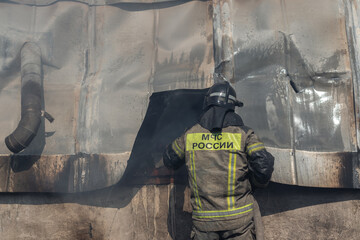 A firefighter from the Russian National Fire Service finishing extinguishing a fire at a warehouse