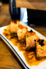 Delicious sushi salmon rolls topped with spicy sauce, high tasty