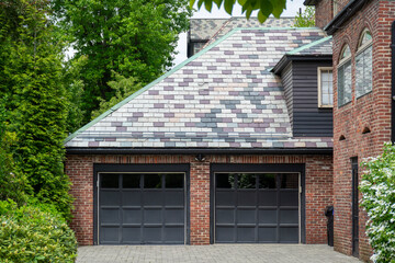 Classic house with double garage doors and patterned slate roof in Brookline, Massachusetts, USA
