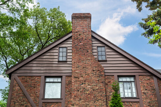 Traditional house exterior with large brick chimney and rustic wooden siding in Brookline, Massachusetts, USA
