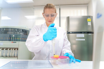 Scientist conducting experiments in a laboratory using a pipette for sample preparation