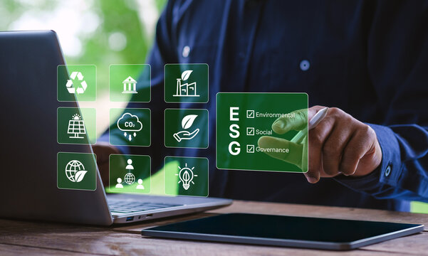 ESG concept, Businessman using digital interface on laptop with environmental, social, and governance icons, sustainability strategy, corporate responsibility, carbon footprint, green business