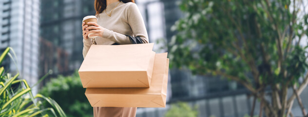 Single adult business asian woman holding coffee cup and shopping bag on black friday sale city...