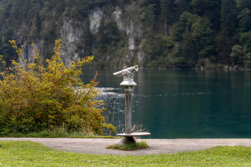 Scenic lakeside view with binoculars for visitors at a serene location, showcasing nature's beauty...