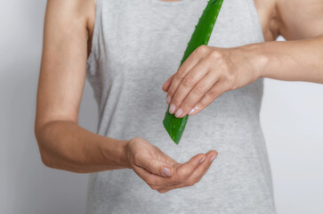 Moisturizing skin of hands with aloe juice. Woman with leaf of green aloe vera. Organic cosmetology.