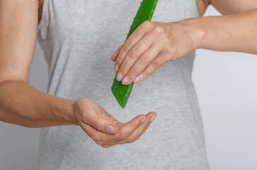 Moisturizing skin of hands with aloe juice. Woman with leaf of green aloe vera. Organic cosmetology.