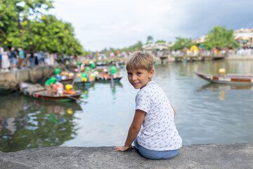 Happy european family, visting Hoi An city in Vietnam for a summer vacation, trying traditional food na watching the show in Memories Land
