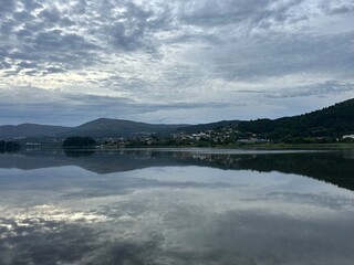 Cloud reflections over tranquil river Minho and surrounding mountains, Tabagón, O Rosal, Galicia, Spain, August 2024