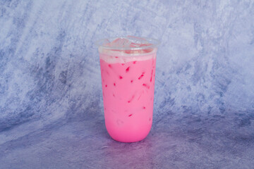 pink strawberry milkshake on grey table in cafe.