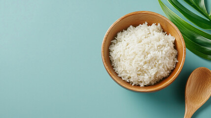 Fluffy White Rice in Wooden Bowl with Tropical Leaf and Spoon