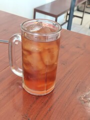 Refreshing iced tea with a full glass of ice on a wooden table. A perfect cool beverage to quench...