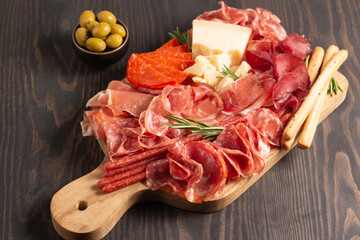 Charcuterie board. Antipasti appetizers of meat platter with salami, prosciutto crudo or jamon and olives.