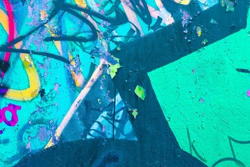 Vibrant graffiti art on textured wall in neon green, blue, yellow. Urban 90s style, funky, bold colors. Street art, digital backgrounds, creative banners, modern 90s, 2000s urban visuals.