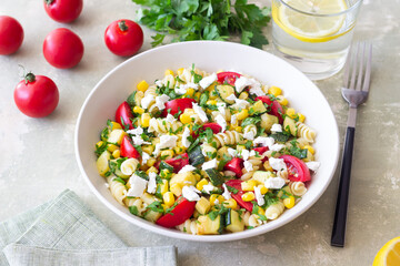 Pasta salad with tomatoes, zucchini, corn and feta cheese. Healthy eating. Vegetarian food.