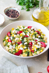 Pasta salad with tomatoes, zucchini, corn and feta cheese. Healthy eating. Vegetarian food.