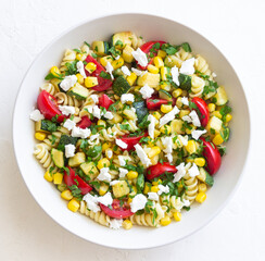 Pasta salad with tomatoes, zucchini, corn and feta cheese. Healthy eating. Vegetarian food.