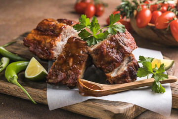 BBQ grilled ribs with vegetables on rustic table, delicious barbecue meal