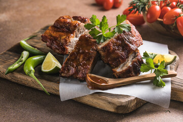 BBQ grilled ribs with vegetables on rustic table, delicious barbecue meal