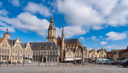Obraz premium Veurne, Belgien – Historischer Marktplatz mit Kirche und Glockenturm bei Tageslicht
