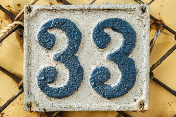 Old retro weathered cast iron plate with number 33