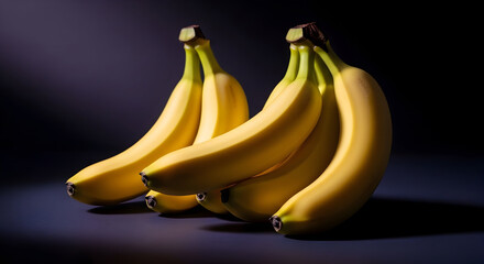 Two bunches of ripe yellow bananas artfully arranged against a dark, moody background.  The dramatic lighting accentuates their curves and color.