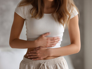Young woman suffering from stomach ache at home, closeup view