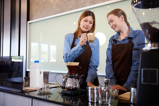 young barista woman making fresh coffee from machine and checking quality in the cafe