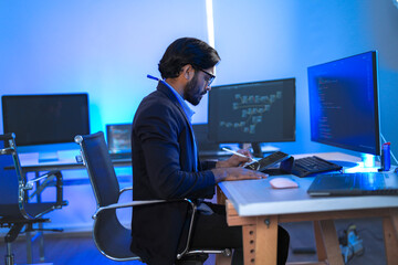 Stressed IT professional reacts with shock to a critical system error on his computer. A developer...