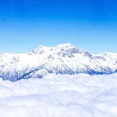 Obraz premium Vast Snowy Mountain Range Above a Sea of Clouds