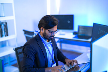 An AI engineer in glasses actively points at code on a monitor, explaining complex algorithms in a...
