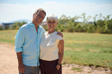 Happy senior couple smiling and embracing outdoors in nature